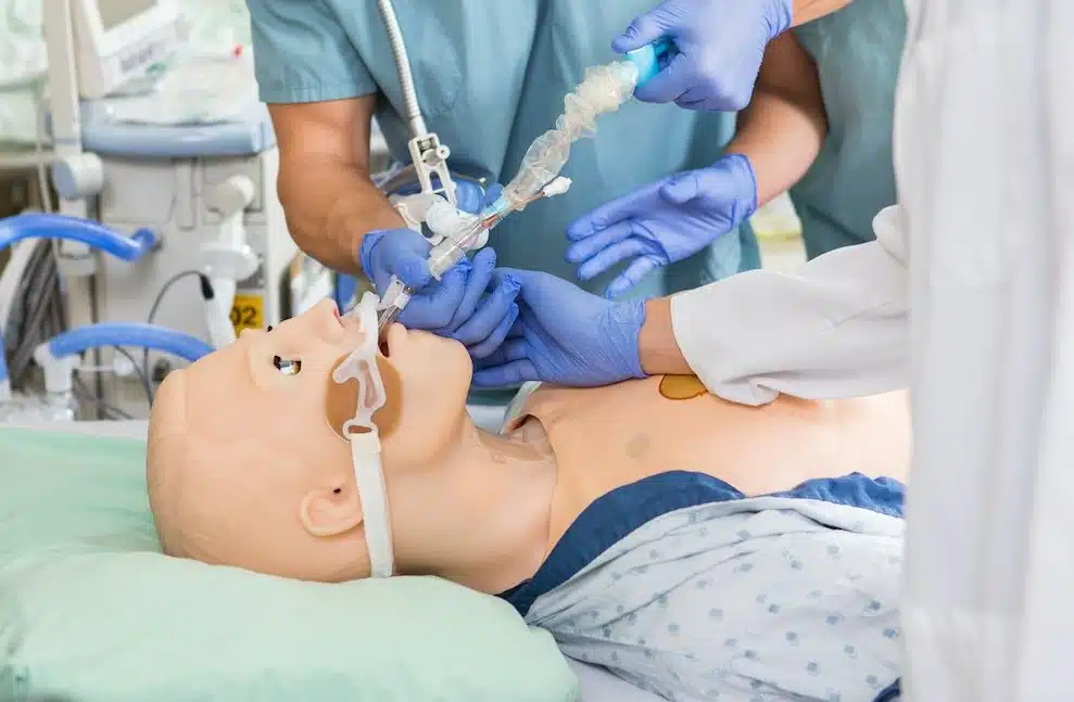 Healthcare simulation training showing clinicians performing airway management on a medical mannequin during Clinical Simulation 101 course